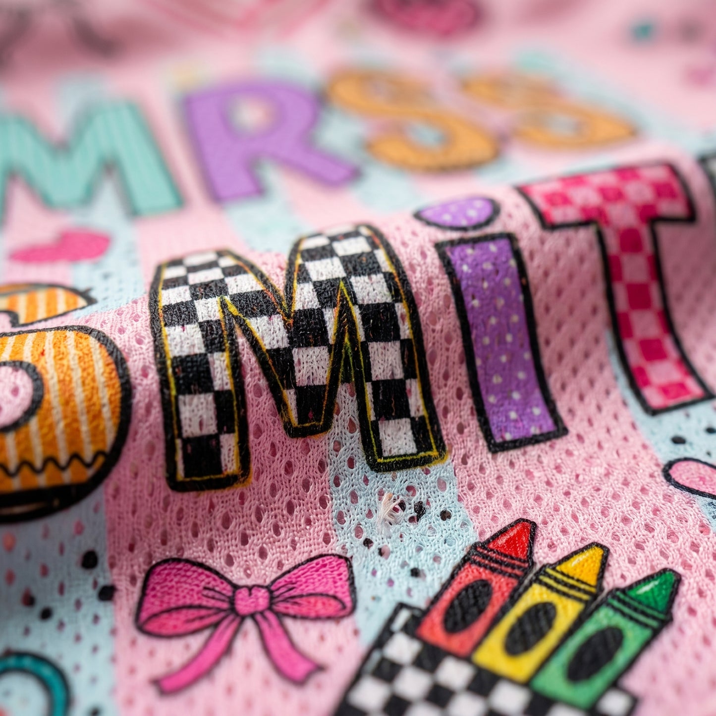 Personalized children's clothing with colorful text and graphics on a pink background
