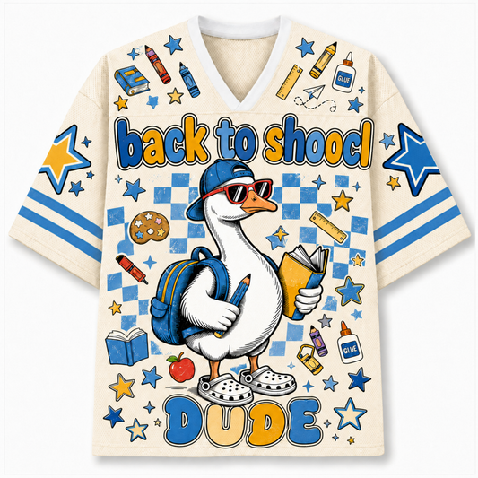 A cream-colored V-neck t-shirt featuring a colorful cartoon graphic of a duck wearing a blue cap, sunglasses, and a backpack, surrounded by school-themed doodles like stars, crayons, books, and an apple. The text 'back to schoo' is written across the chest in blue and yellow, and 'DUDE' is printed at the bottom.