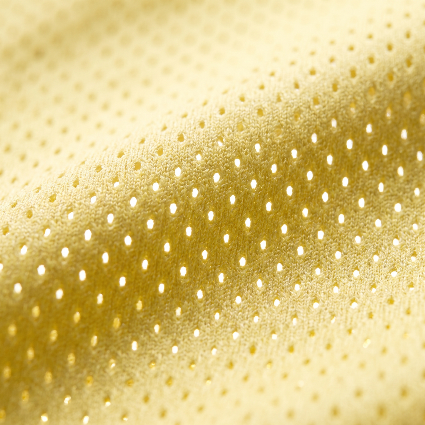 Extreme macro shot of the yellow pro-mesh breathable fabric, highlighting the airy knit texture designed for maximum comfort during hot summer days.