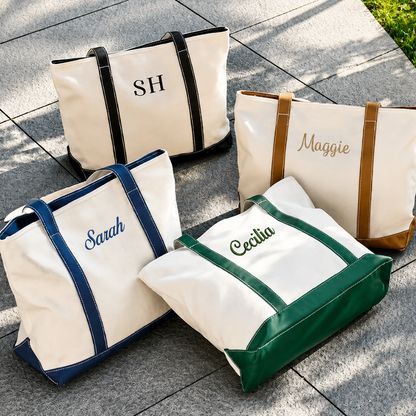 Four personalized tote bags with names embroidered on them, placed on a stone surface.