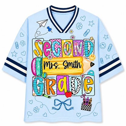 Front view of the light blue ChaoticClub Doodle Back to School Teacher Mesh Jersey, featuring colorful patchwork "SECOND GRADE" text, a large yellow pencil graphic with customizable "Mrs. Smith" name, and small school doodles.