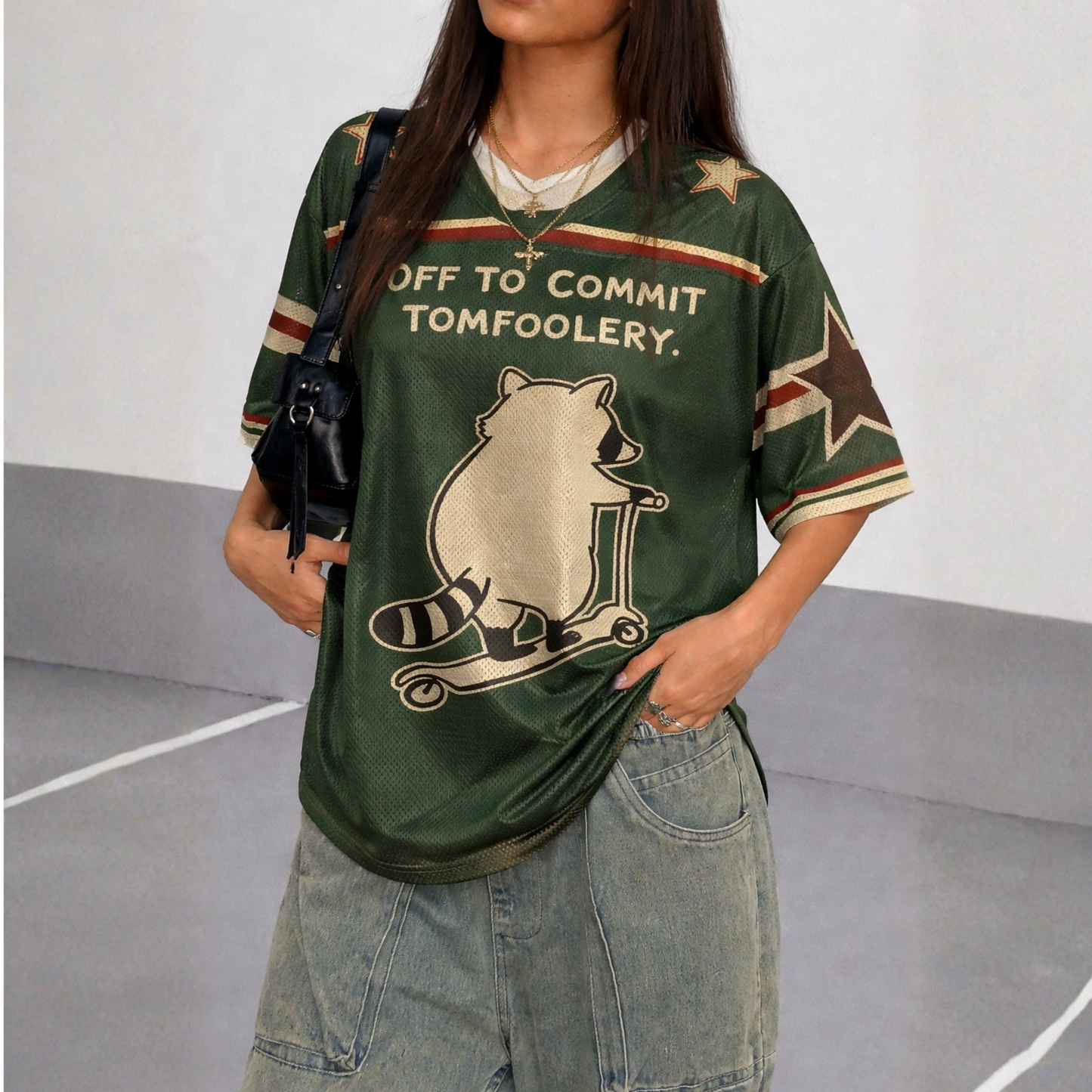 ChaoticClub Off To Commit Tomfoolery Mesh Jersey, vintage athletic oversized jersey on forest green and cream breathable mesh featuring a raccoon riding a scooter with "Off to commit tomfoolery" funny sarcastic text.