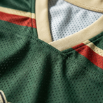ChaoticClub Off To Commit Tomfoolery Mesh Jersey, vintage athletic oversized jersey on forest green and cream breathable mesh featuring a raccoon riding a scooter with "Off to commit tomfoolery" funny sarcastic text.
