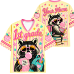 Front and back views of the ChaoticClub Pastel Bubblegum Raccoon Teacher Mesh Jersey. Front displays the raccoon with a backpack and "1st grade" text, while the back shows the raccoon sitting on books with customizable name text.