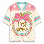 Front view of the ChaoticClub Preppy Back to School Teacher Apple Mesh Jersey, featuring a cute apple graphic with a pink bow, colorful polka dots, and gold glitter "first grade" text.