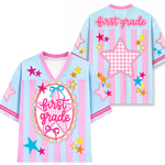 Children's shirt with 'first grade' text and star designs on a light blue background