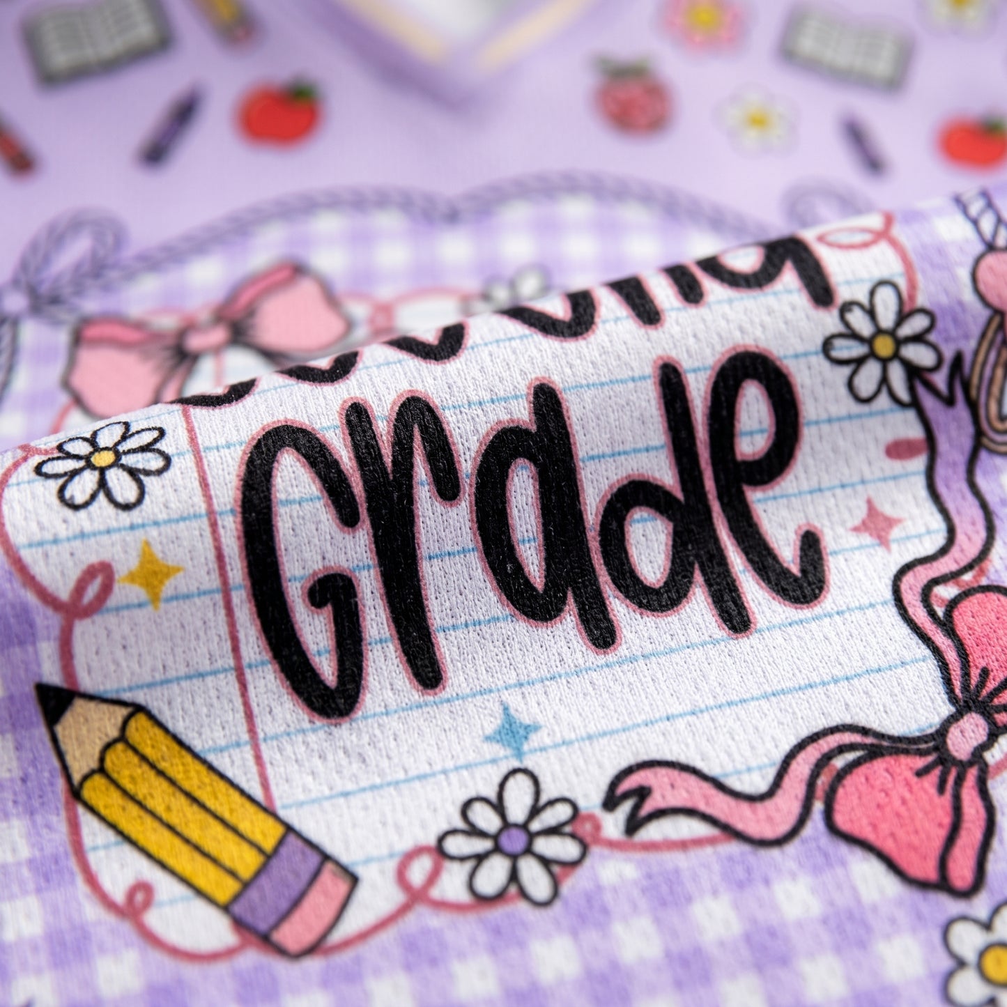 Pencil case with 'First Grade' text on a purple background with school-themed decorations.
