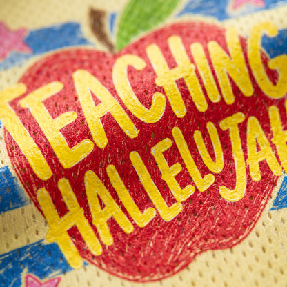 Red apple-shaped pillow with 'Teaching Hallelujah' text on a colorful background