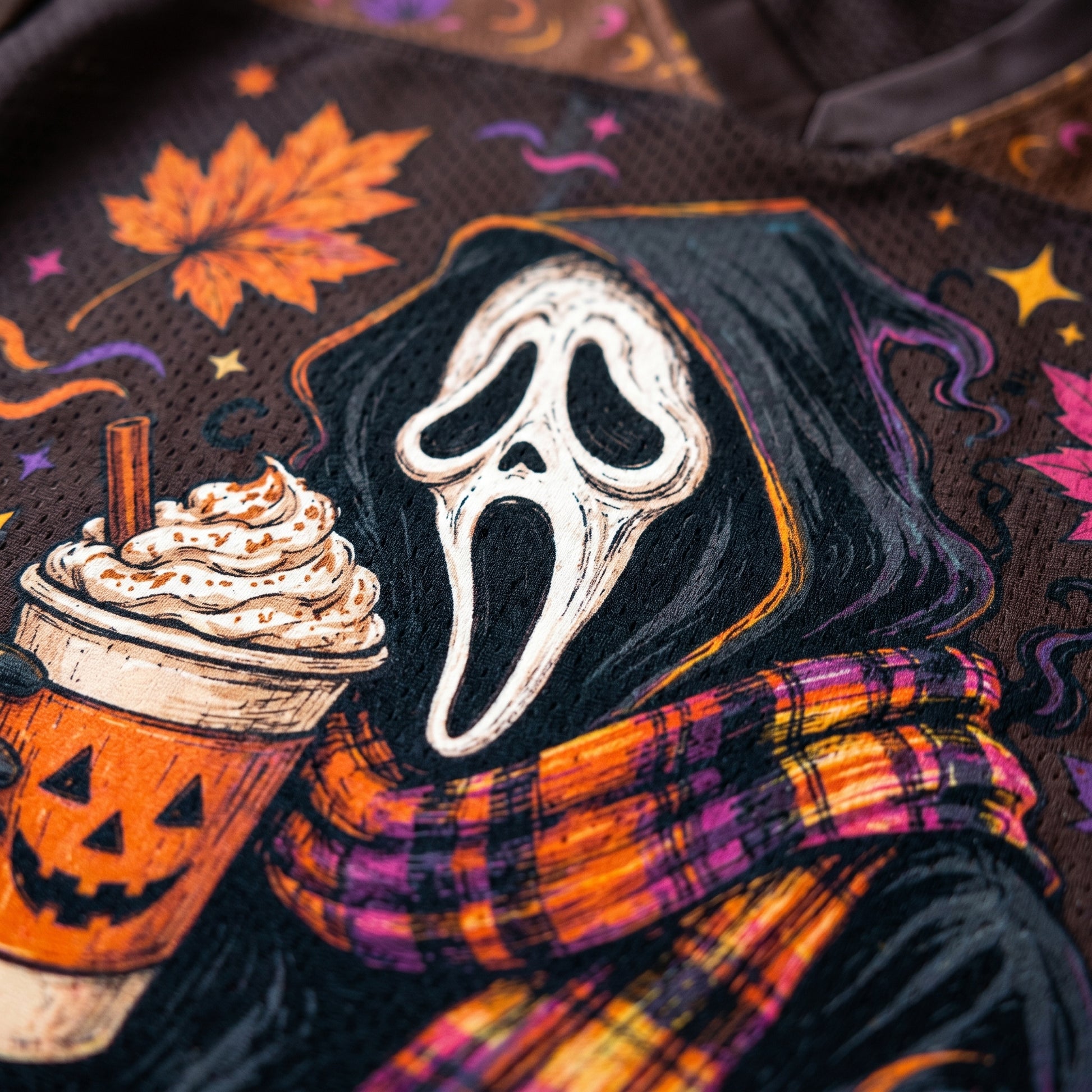 Halloween-themed design with ghost face, pumpkin spice latte, and plaid scarf on a dark background.
