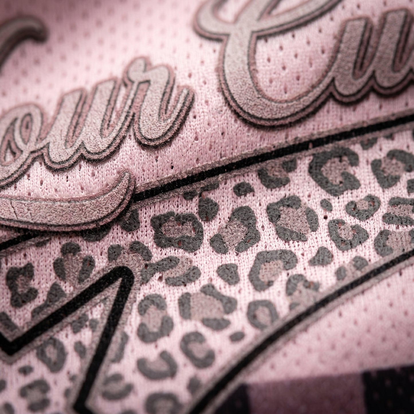 Close-up of a product with leopard print pattern and 'our' text on a pink background