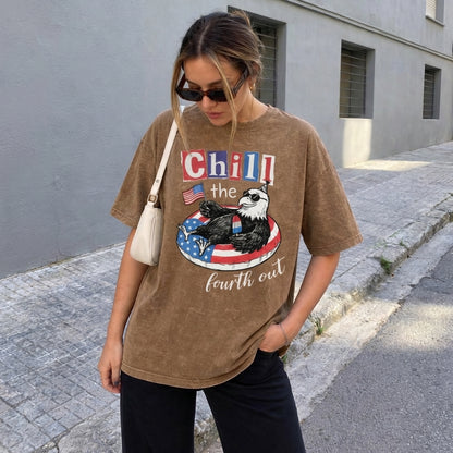 ChaoticClub Chill The Fourth Out Eagle Washed T-Shirt, vintage oversized graphic tee featuring a cool bald eagle in sunglasses and a party hat lounging in a patriotic pool float with a popsicle and an American flag with funny text on premium washed cotton fabric