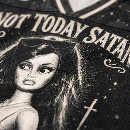 Close-up of a black graphic print featuring a stylized doll face with the text 'NOT TODAY SATAN' and celestial details.