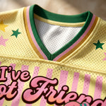 Yellow sports jersey with colorful text and star designs on a blurred background