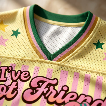 Yellow sports jersey with colorful text and star designs on a blurred background