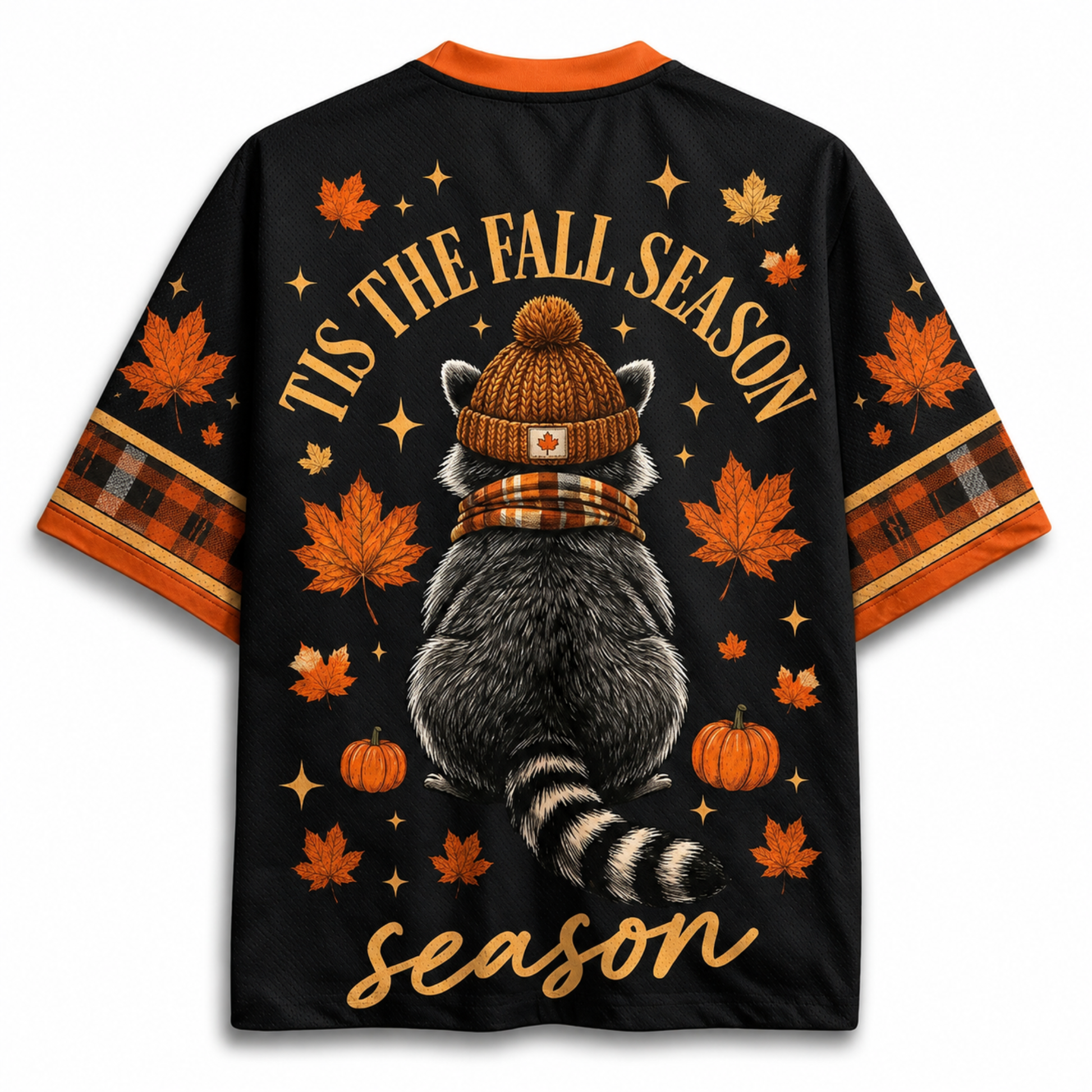 A black short-sleeve t-shirt with an all-over autumn-themed graphic print. The design features a raccoon wearing a brown knit beanie and plaid scarf, surrounded by orange maple leaves, pumpkins, stars, and the text 'TIS THE FALL SEASON season'.