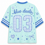 The back of a light blue mesh short-sleeve jersey with blue trim, featuring 'blue devils' in script and the number '03' in a blue-and-white gingham pattern. The sleeves have blue and white stripes, and the back is decorated with blue stars, hearts, and bows.