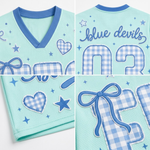 Product compilation highlighting the solid blue V-neck ribbed collar, blue and white sleeve athletic stripes, gingham heart badge, and breathable mesh fabric.