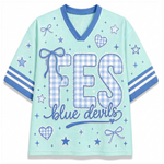 A light mint green short-sleeve V-neck t-shirt with blue trim, featuring a 'FES blue devils' graphic on the front with gingham patterned letters and blue star, heart, and bow motifs.