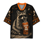 A black short-sleeve V-neck t-shirt with an orange collar, featuring a detailed graphic of a raccoon wearing sunglasses and holding a can labeled 'CUSTOM ANY DRINK' with Halloween motifs like ghosts, bats, moons, and pumpkins on the sleeves and background.