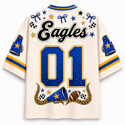 A cream-colored short-sleeve sports jersey shown from the back, featuring 'Eagles' in black script across the shoulders, a large blue and gold '01' on the back, and various blue, yellow, and black graphic accents including stars, checkered flags, and megaphones.