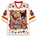 An off-white short-sleeve V-neck jersey with red and yellow trim, featuring a large graphic on the front with a football, stars, checkered patterns, the word 'Bulldog', and 'No. 1'.