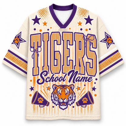 A custom sports jersey with a cream mesh body, purple and orange graphics, and a tiger head design on the front. The text reads 'TIGERS School Name' with paw print accents.