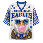 A white V-neck athletic jersey with blue and gold graphics, featuring a bald eagle wearing blue and gold jewelry and blowing a pink bubblegum bubble. The jersey has 'SCHOOL NAME EAGLES' printed across the chest, blue leopard-print sleeves, and blue and gold star details.