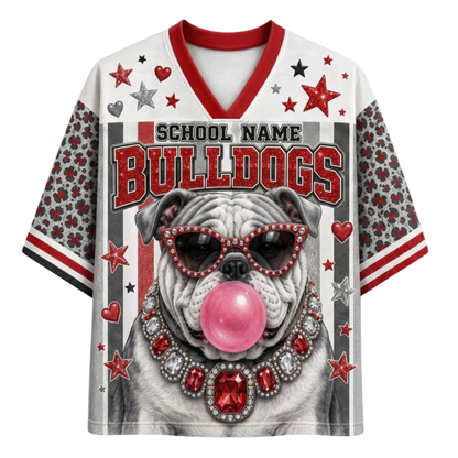 A customizable short-sleeve athletic jersey featuring a bulldog wearing sunglasses and a jeweled collar blowing pink bubblegum, with 'BULLDOGS' text and 'SCHOOL NAME' placeholder text on the front.
