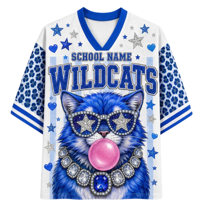 A white and blue short-sleeve V-neck jersey-style shirt with 'SCHOOL NAME WILDCATS' text and a large blue cat graphic wearing star-shaped sunglasses and a jeweled collar, on a plain white background.