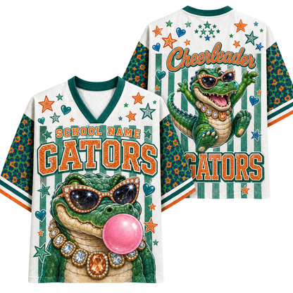 Front and back views of a white V-neck cheerleader jersey with green trim, featuring a cartoon alligator wearing sunglasses and a gold necklace, stars, hearts, and the words 'School Name Gators' and 'Cheerleader'.