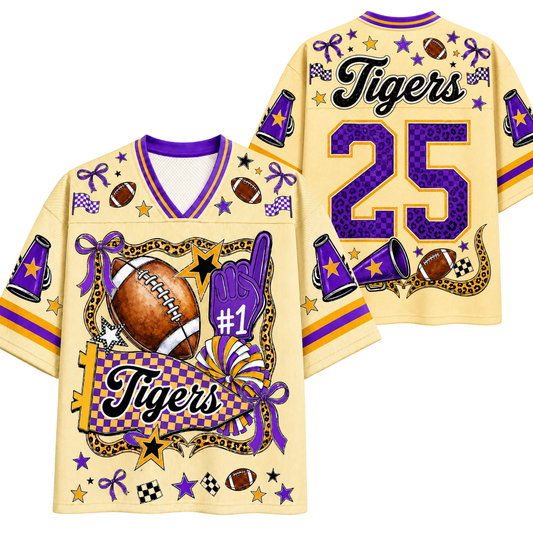 A custom football jersey shown from both the front and back. The jersey is a pale yellow color with purple and gold accents, featuring the word 'Tigers', the number '25', and various football-themed graphics including a football, purple foam finger, stars, and checkered patterns.