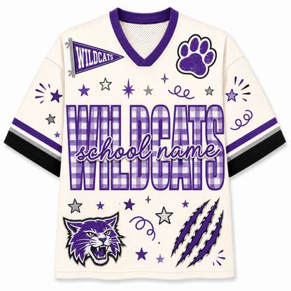 A custom white and purple short-sleeve V-neck jersey with 'WILDCATS' and 'school name' text, a paw print, a wildcat head graphic, stars, stripes, and claw marks on the front.