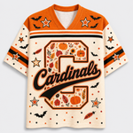 Front view of the cream varsity jersey displaying a large plaid monogram letter with script 'Cardinals' text surrounded by black bats and pumpkin doodles.