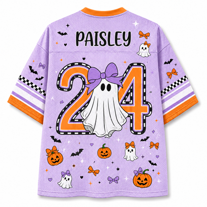A light purple mesh short-sleeve jersey shown from the back, featuring a personalized Halloween design with the name 'PAISLEY' and number '24' in orange and black, a white ghost, pumpkins, bats, and bows.