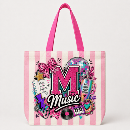 A pink and white striped tote bag featuring a colorful 'Music' graphic design with a glittery pink letter 'M', a disco ball, a bow, and musical instruments.