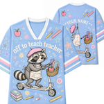 A light blue graphic t-shirt shown from both the front and back. The front features a cartoon raccoon wearing glasses and a pink beret, riding a scooter with books and a pencil basket.