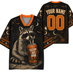 A Halloween-themed custom graphic t-shirt shown from both front and back. The black shirt features an orange and gray raccoon wearing sunglasses and holding an orange can labeled 'CUSTOM ANY DRINK'.