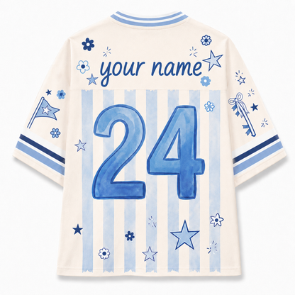 Back view of a customizable short-sleeve jersey in cream with light blue vertical stripes, featuring a large blue number 24, 'your name' text, and blue star and flower graphics.