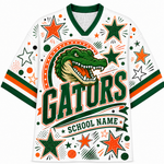 A white V-neck athletic jersey with green and orange collegiate graphics, featuring a large alligator head, the word 'GATORS' in bold green letters, decorative stars, dots, and stripes, and a banner reading 'SCHOOL NAME'.