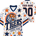Customizable white V-neck football jersey shown from the front and back, featuring a tiger graphic, 'Tigers' text, 'School Name' banner, and placeholder text 'Your Name' and number '10' in navy and orange with star and confetti patterns.