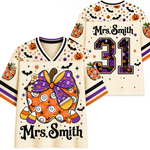 Front and back views of a custom hockey-style jersey with a Halloween theme. The cream-colored mesh jersey features orange pumpkins, black bats, purple bows, candy corn, and the text 'Mrs.