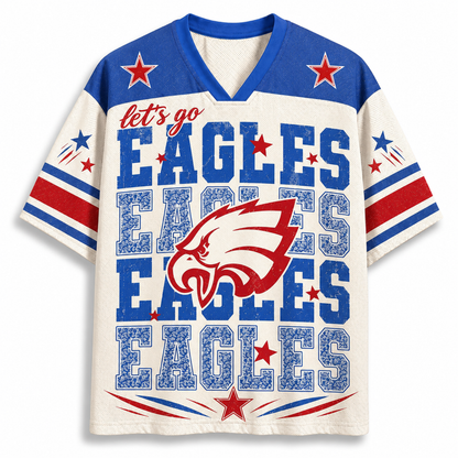 A short-sleeve V-neck t-shirt with a distressed Philadelphia Eagles theme. The shirt features a cream-colored body, blue shoulders and collar, red and blue star accents, and the text 'let's go EAGLES EAGLES EAGLES' along with an eagle head logo on the front.