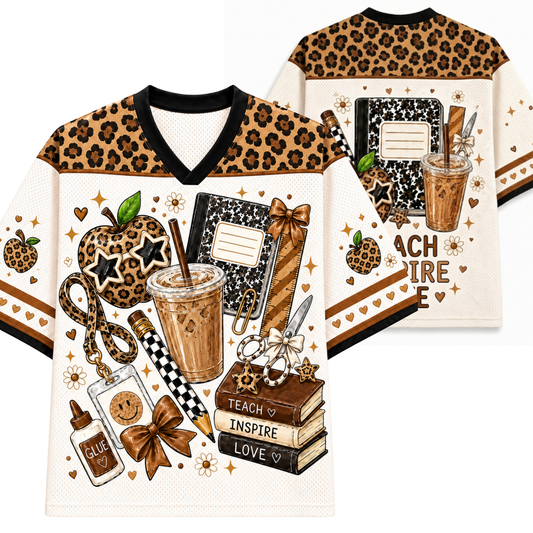 A V-neck graphic T-shirt shown from the front and back on a white background. The shirt features a tan and black leopard print shoulder yoke, a cream body, and a detailed autumn-themed graphic print with an apple, notebook, coffee cup, books, and the words 'TEACH INSPIRE LOVE'.