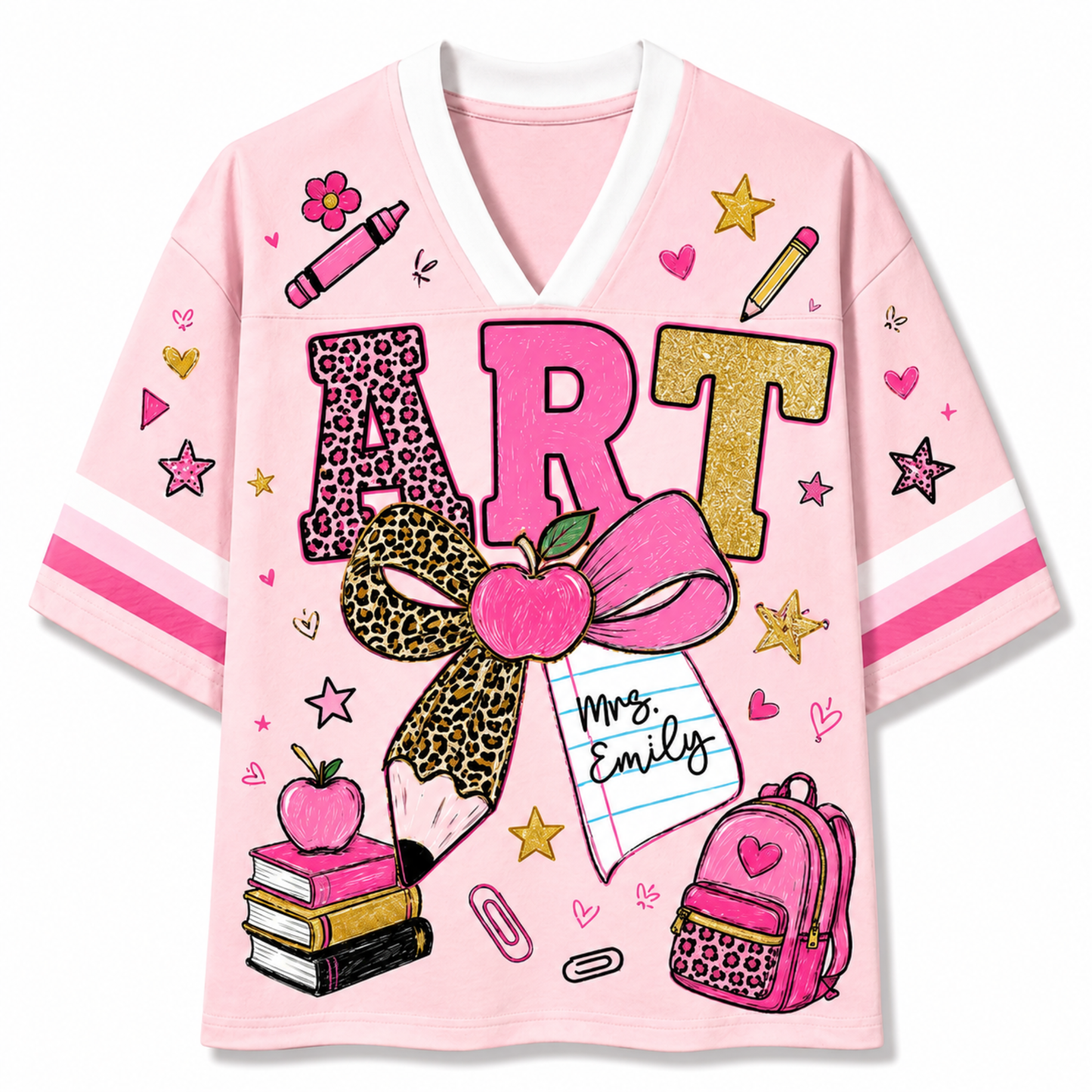 A pink V-neck t-shirt with a school-themed graphic print featuring the word 'ART' in leopard print and glitter textures, decorated with an apple bow, notebook, books, and stars.