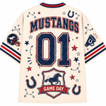 A cream-colored short-sleeve t-shirt with a distressed navy and red 'Mustangs Game Day' football graphic on the back, featuring '01' and various horse-themed illustrations.