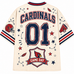 Back view of a cream-colored Cardinals '01' jersey with navy and red lettering, star graphics, a football helmet, and a 'Game Day' shield on the sleeves and back.