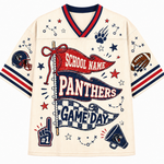 A cream-colored short-sleeve V-neck jersey-style shirt with red and navy trim, featuring a large football-themed graphic print on the front with banners reading 'SCHOOL NAME PANTHERS' and 'GAME DAY,' plus stars, paw prints, a football, helmet, megaphone, and number 1 hand icon.