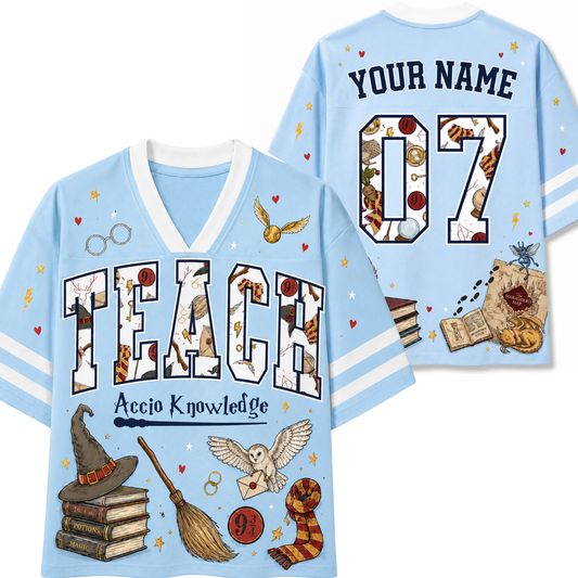 A light blue short-sleeve V-neck T-shirt shown from both front and back, decorated with Harry Potter-themed graphics including the word 'TEACH' in a patterned font, 'YOUR NAME' and '07' on the back, a hat, broom, owl, wand, books, and other magical illustrations.