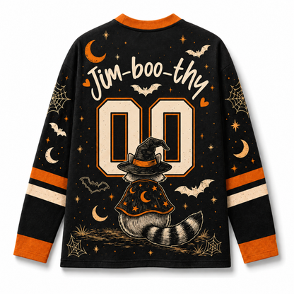 A long-sleeve black Halloween-themed jersey-style shirt shown from the back, with orange and cream graphics including the text 'Jim-boo-thy', large '00' numerals, bats, moons, spiderwebs, stars, and a witch hat and tail illustration.