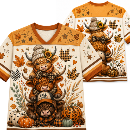 A long-sleeve V-neck graphic T-shirt shown from both front and back, featuring a stacked Highland cow illustration with autumn elements including pumpkins, plaid, stars, leaves, and sunflowers on an off-white background.